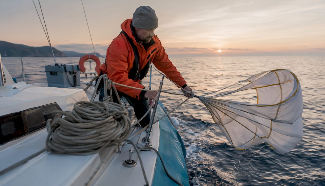 Sailor deploying sea anchor at yacht bow