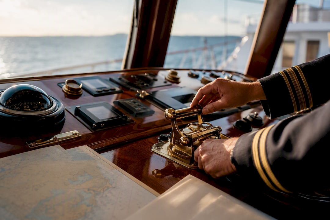 Captain's hand adjusting yacht navigation controls